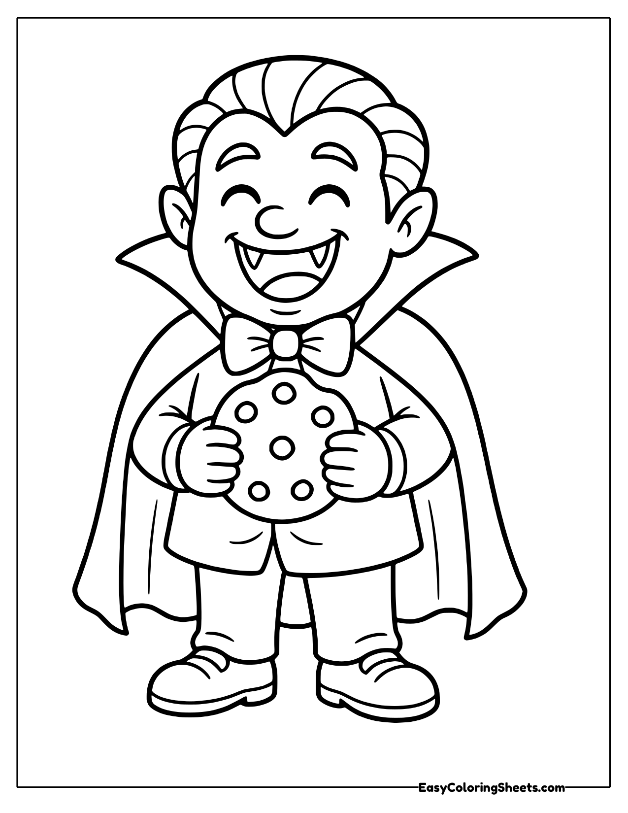 Laughing vampire boy holding a cookie