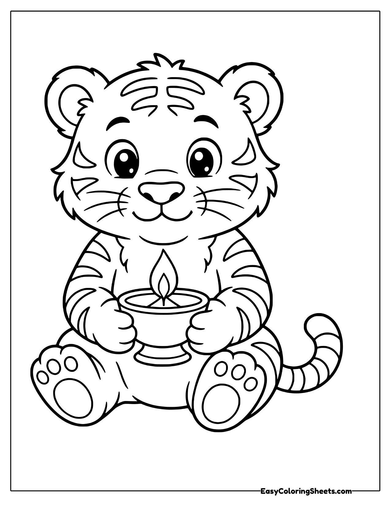A striped tiger cub sits holding a small diya lamp with a bright flame.