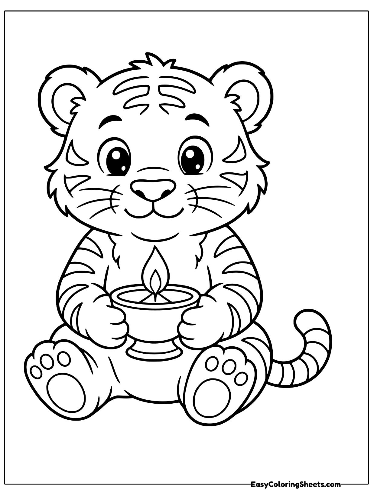 A striped tiger cub sits holding a small diya lamp with a bright flame.