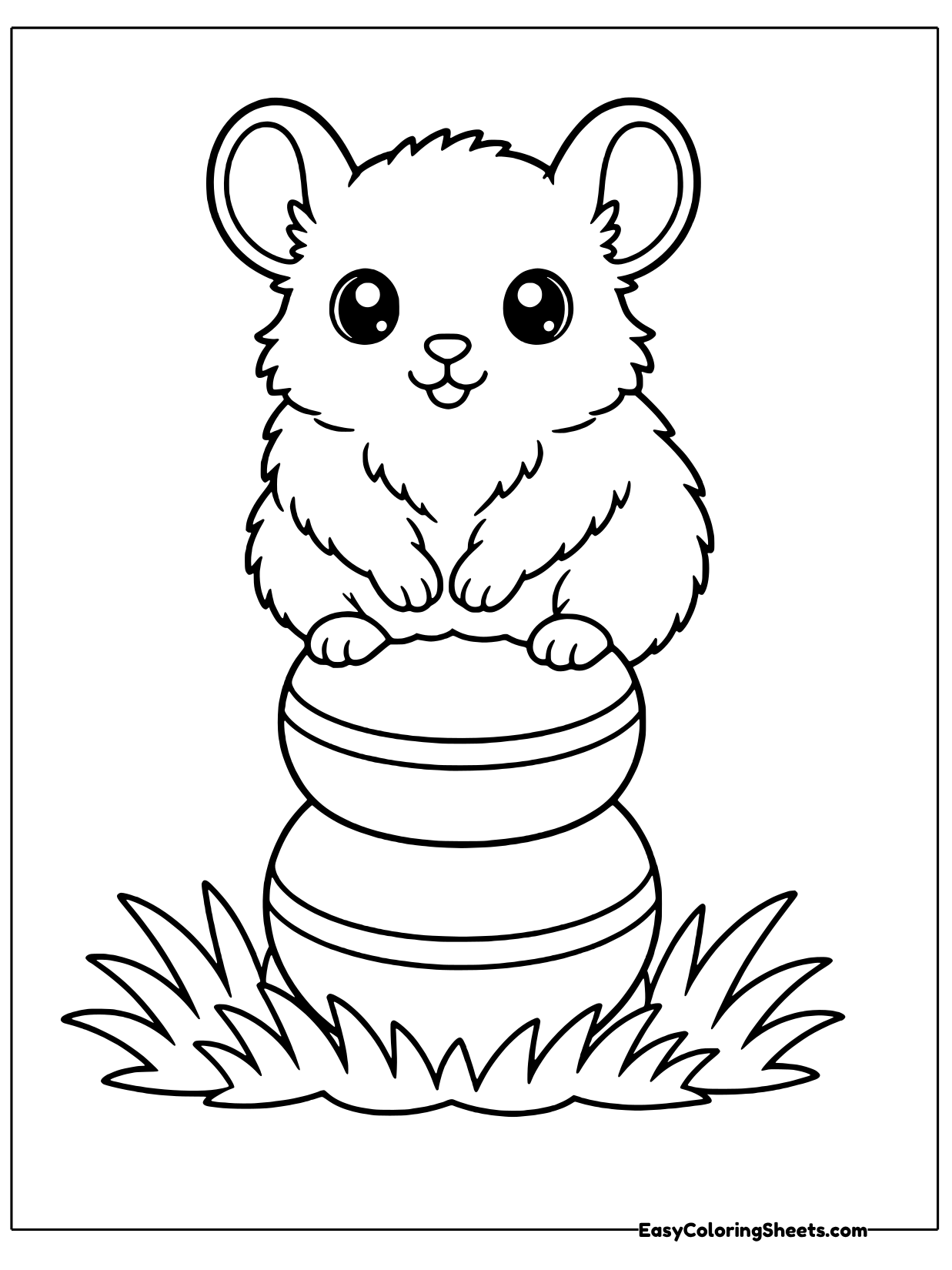 A chinchilla perches on top of a stack of round blocks in a patch of grass with its big ears raised.
