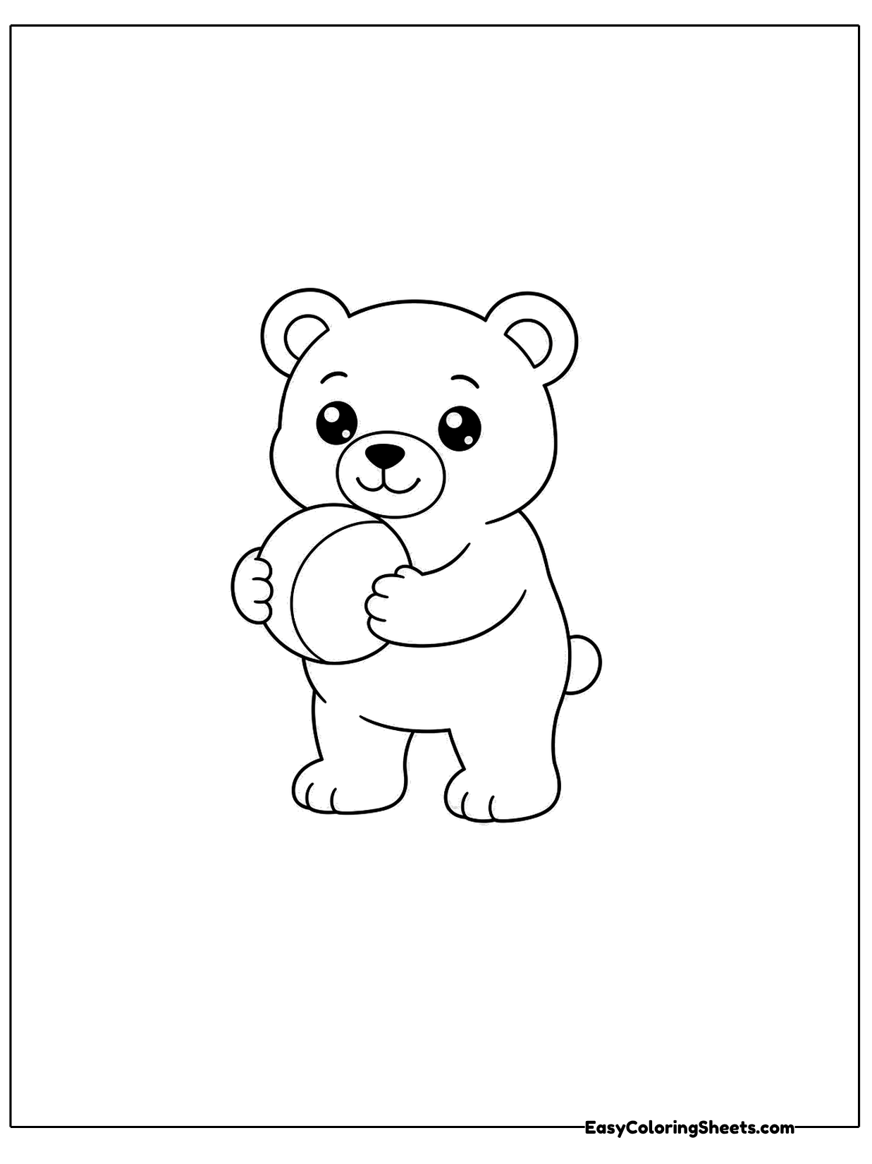 A little bear cub stands holding a round ball against its chest.