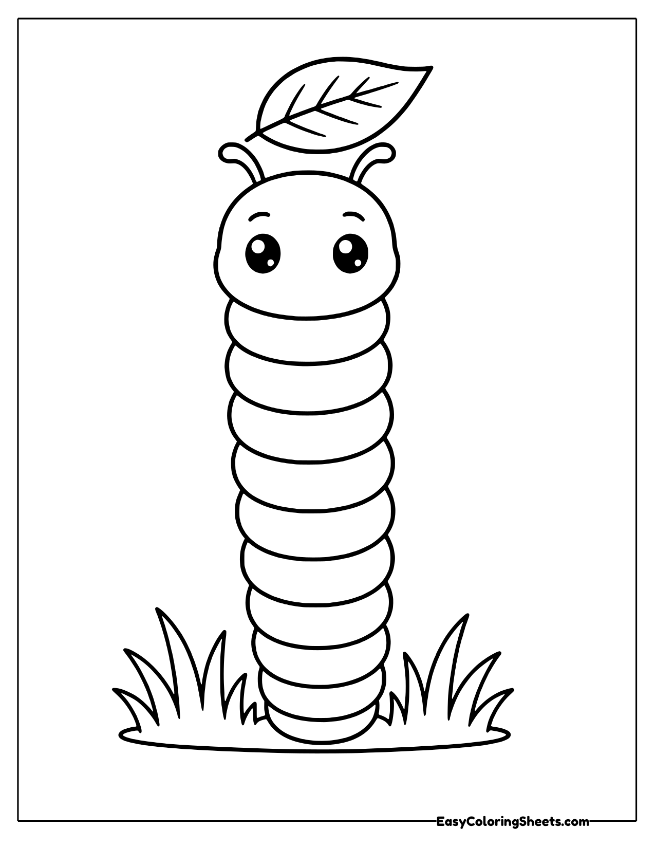 A caterpillar stands straight up in a tuft of grass with a leaf perched on its head like a hat.