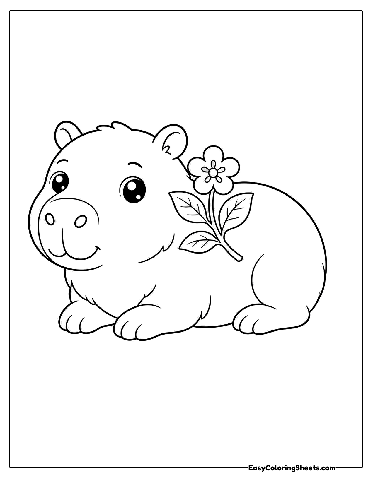 Capybara lying beside a flower