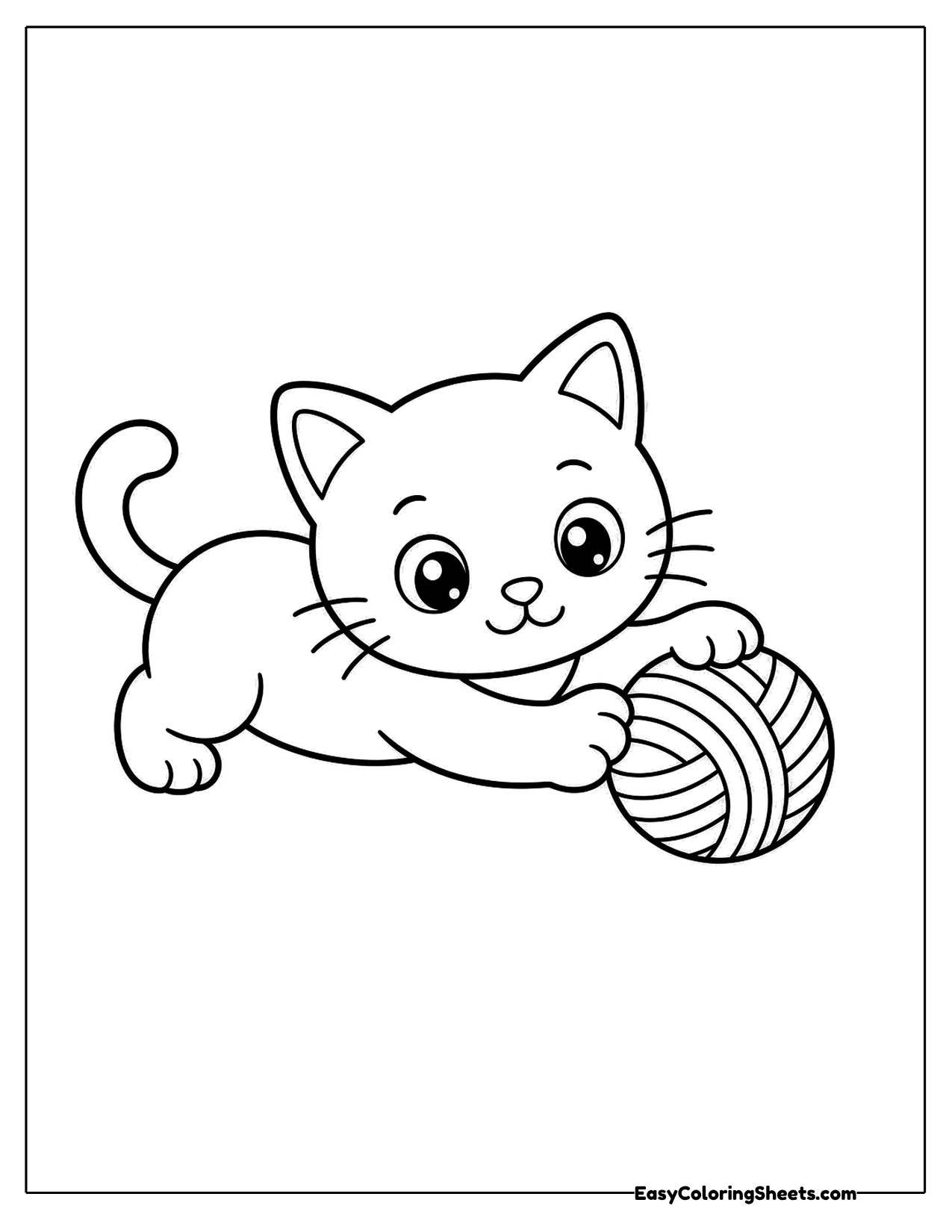 Kitten crouching beside a ball of yarn