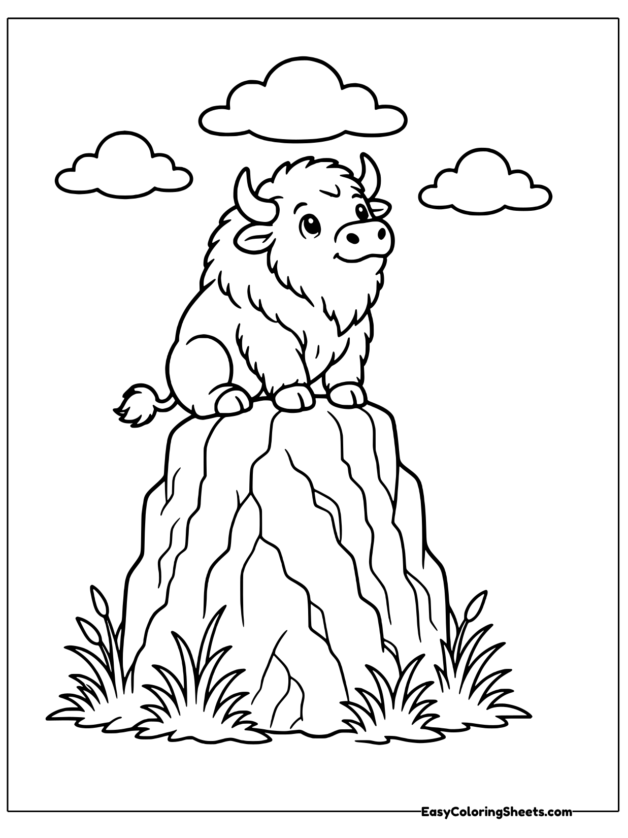 A bison stands on top of a tall rocky ridge with puffy clouds overhead.