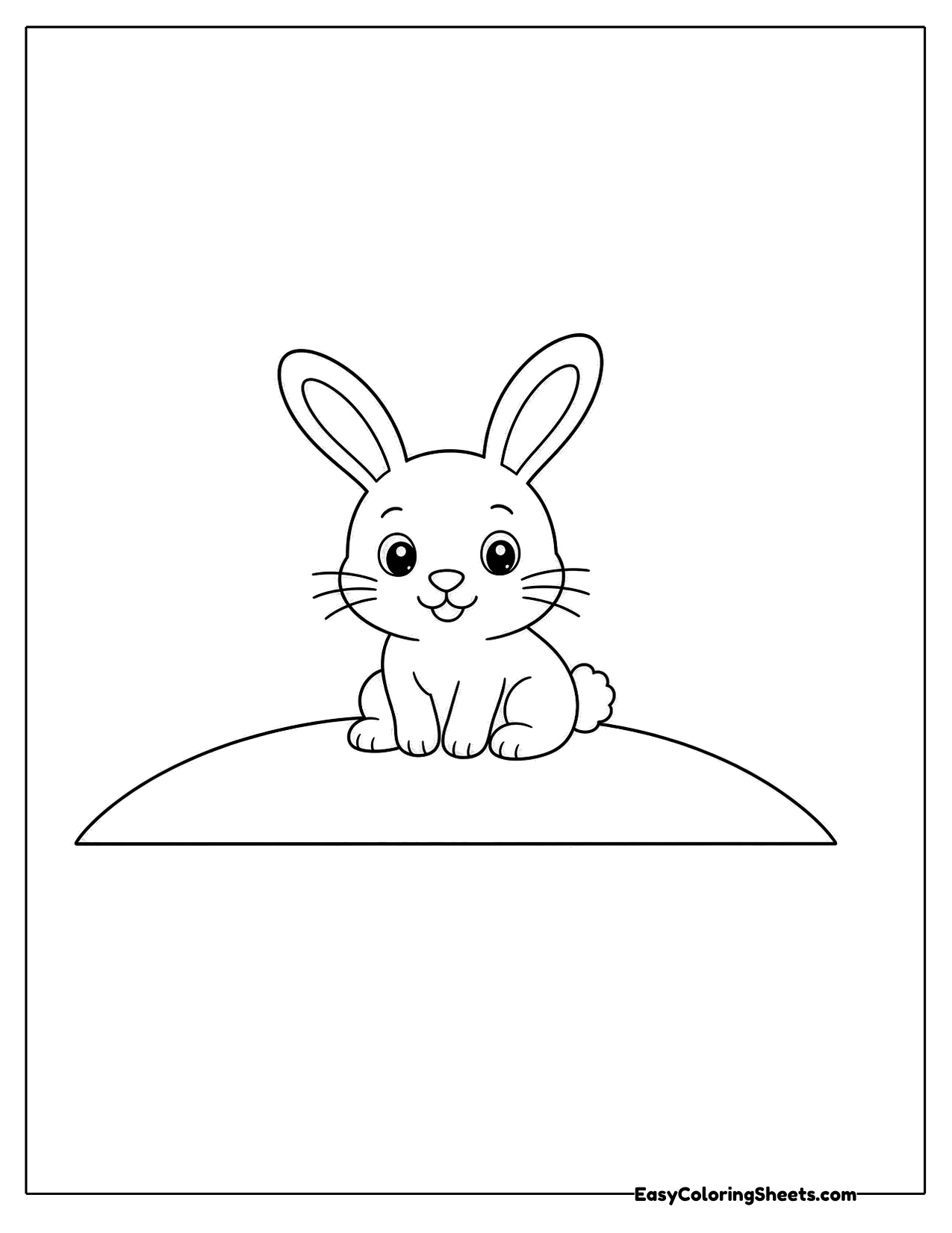 Small bunny sitting on top of a rounded hill