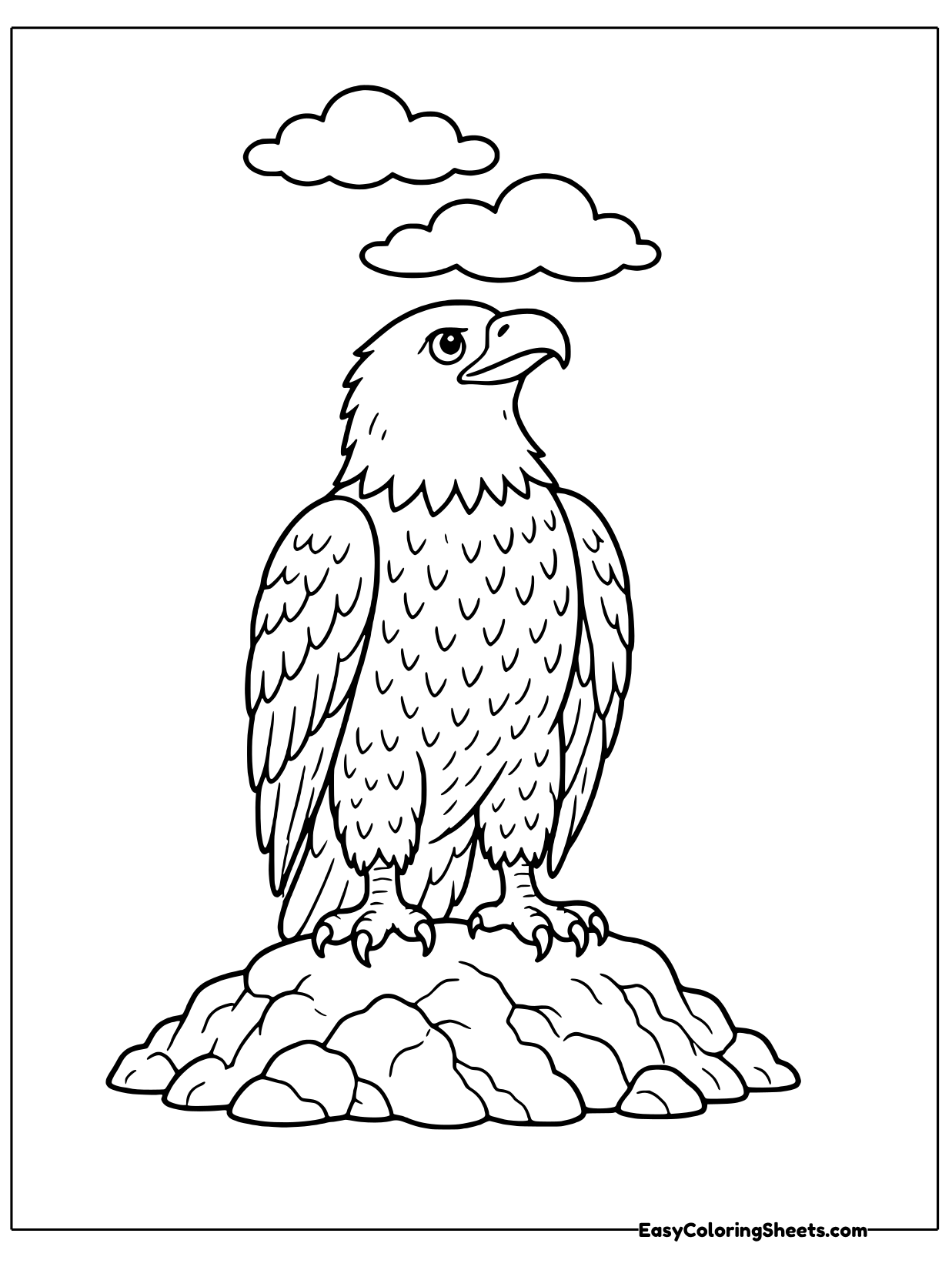 A bald eagle stands on a rock and turns its head upward with clouds overhead.