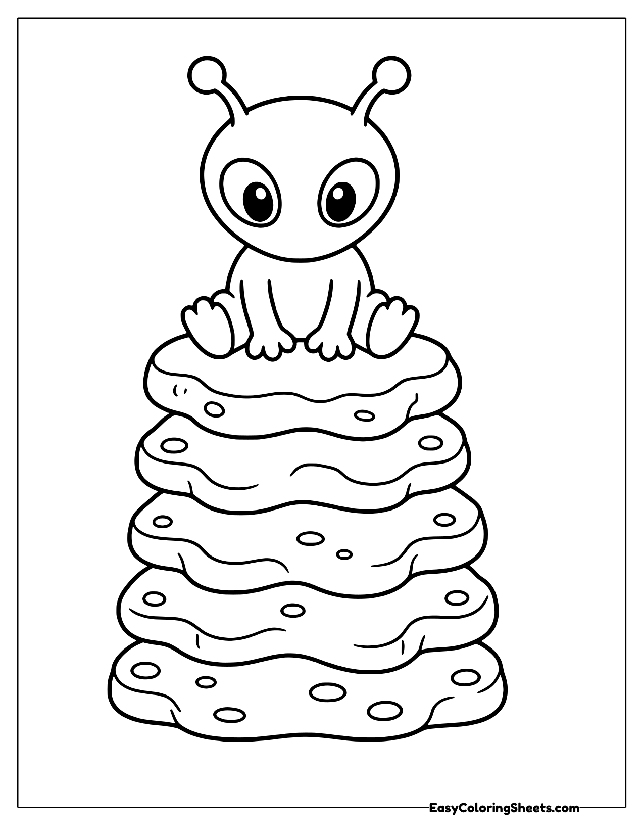 Alien perched on a tall stack of rounded rocks