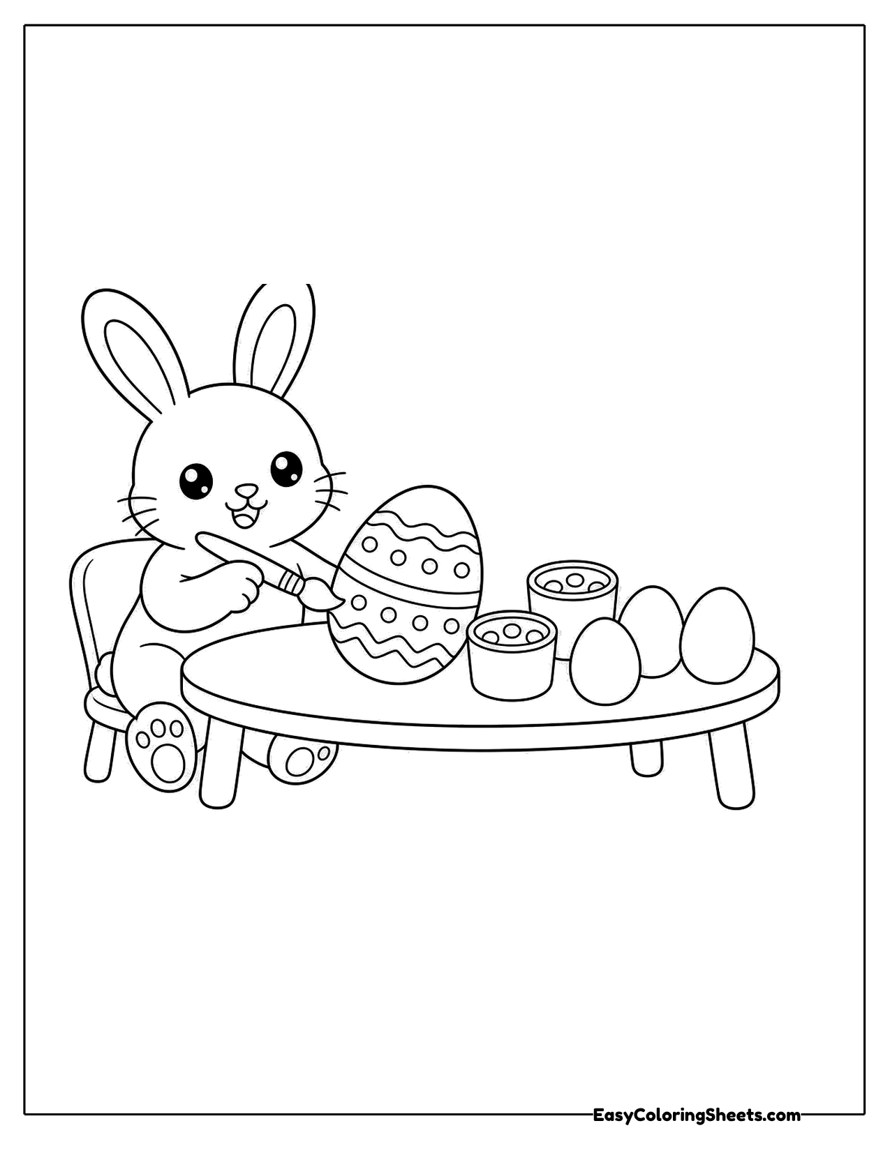 Bunny painting Easter eggs at a table