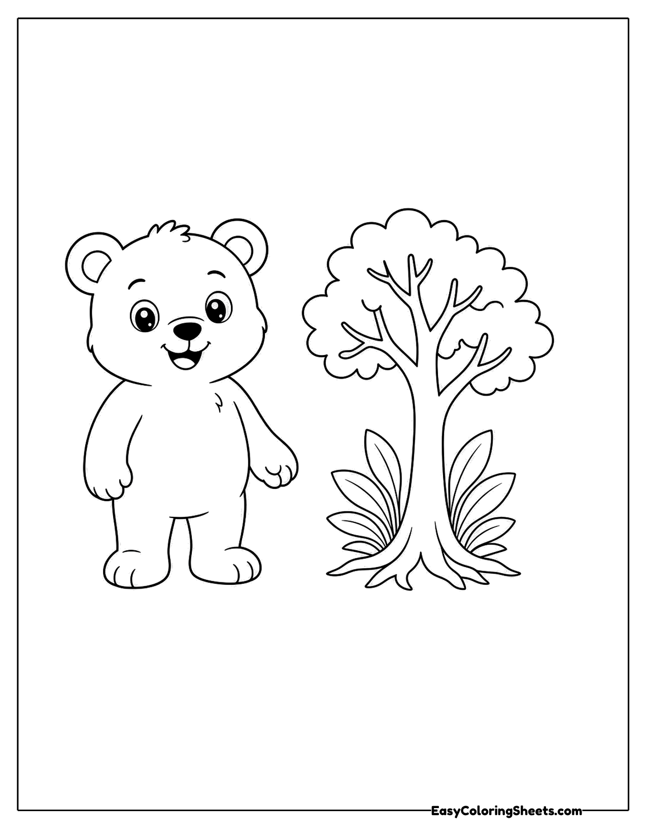 Bear cub standing next to a small tree