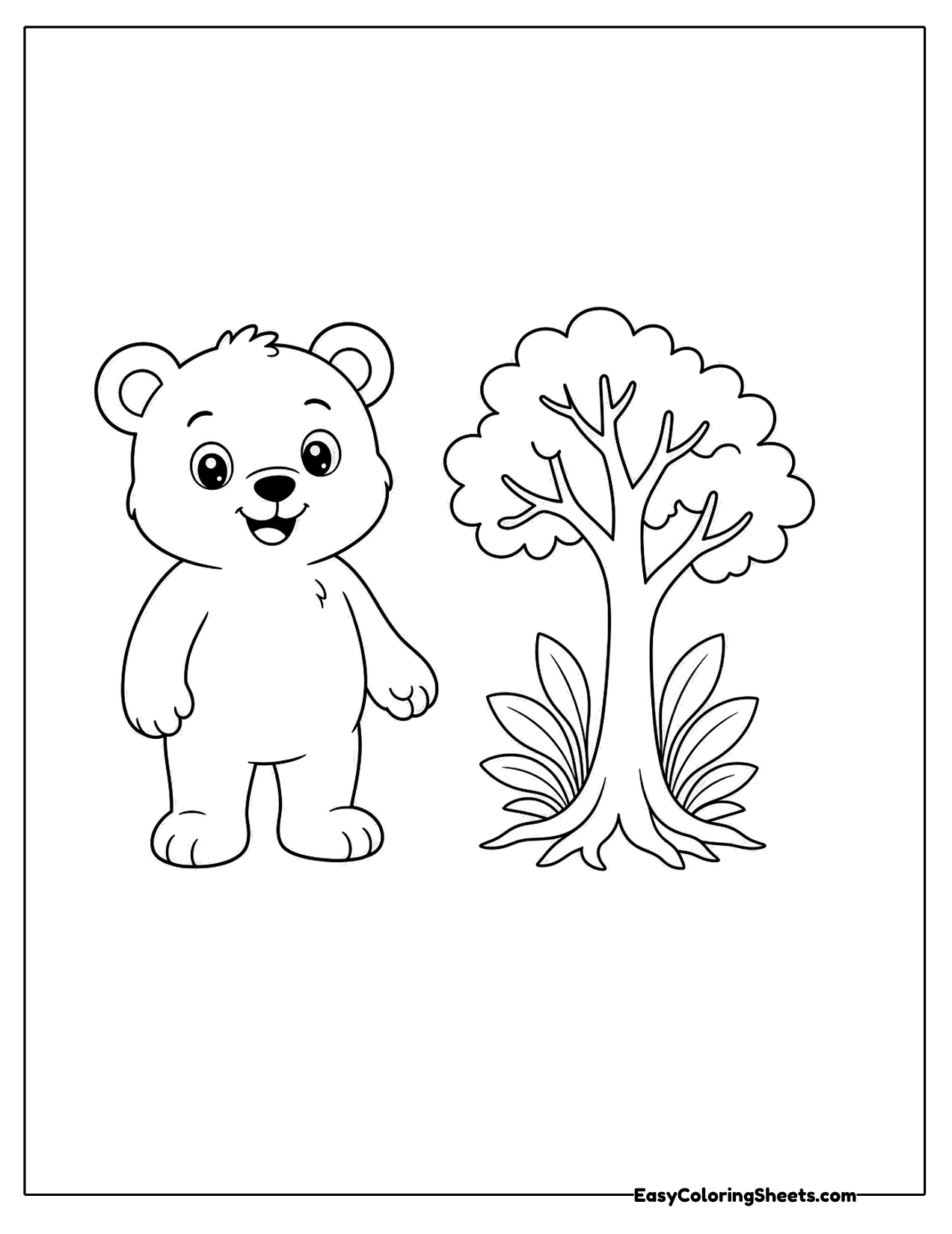 Bear cub standing next to a small tree