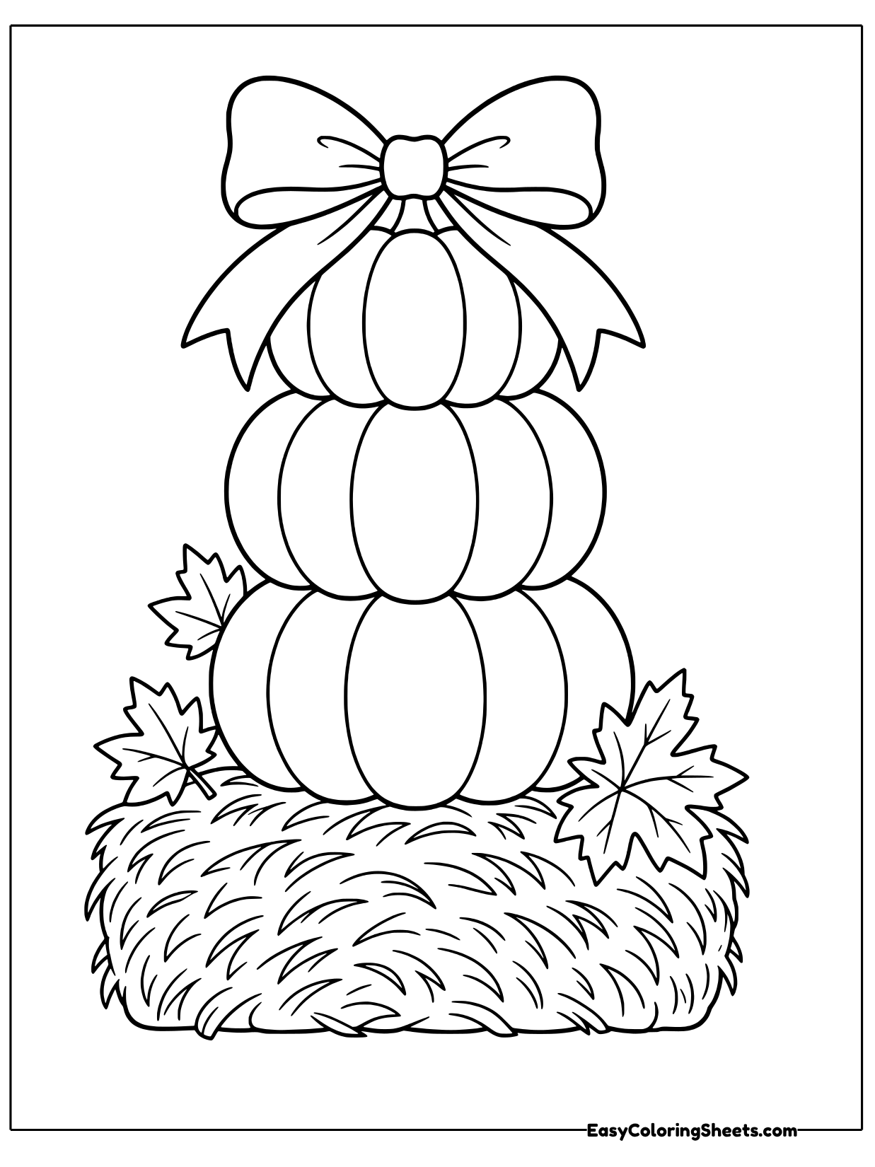 Three pumpkins are stacked into a tower with a big bow on top, sitting on a round hay bale with maple leaves tucked around.