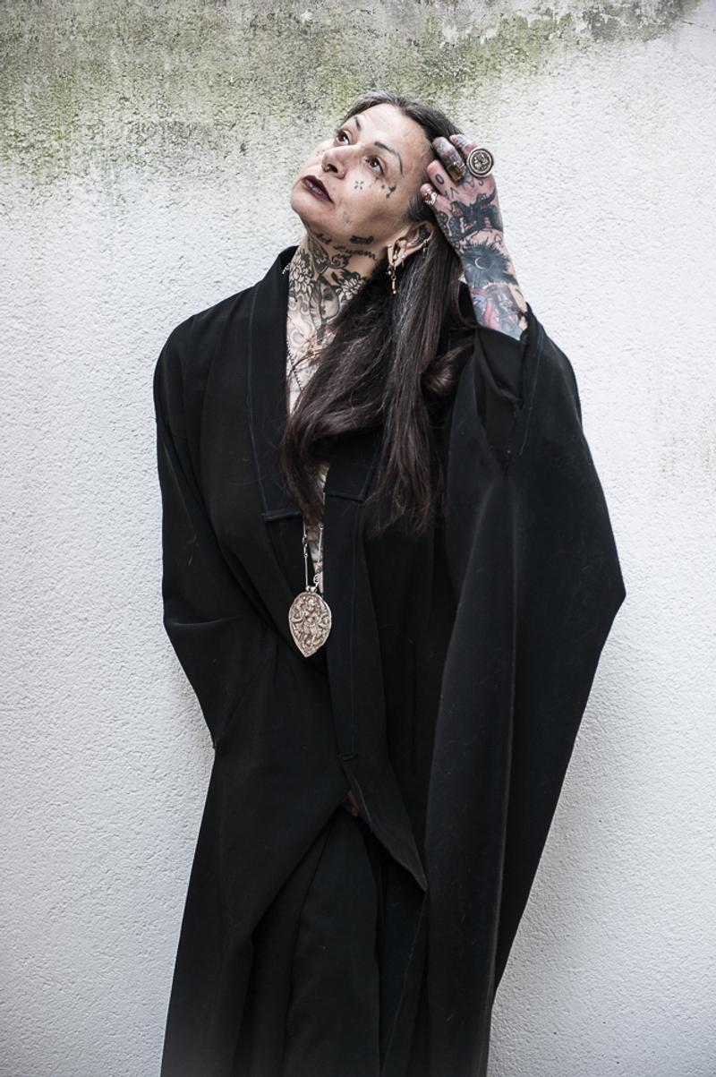 Noema Kali, Leiterin der schamanischen Zeremonien bei Yogicescape Berlin, in schwarzer Robe mit rituellem Anhänger