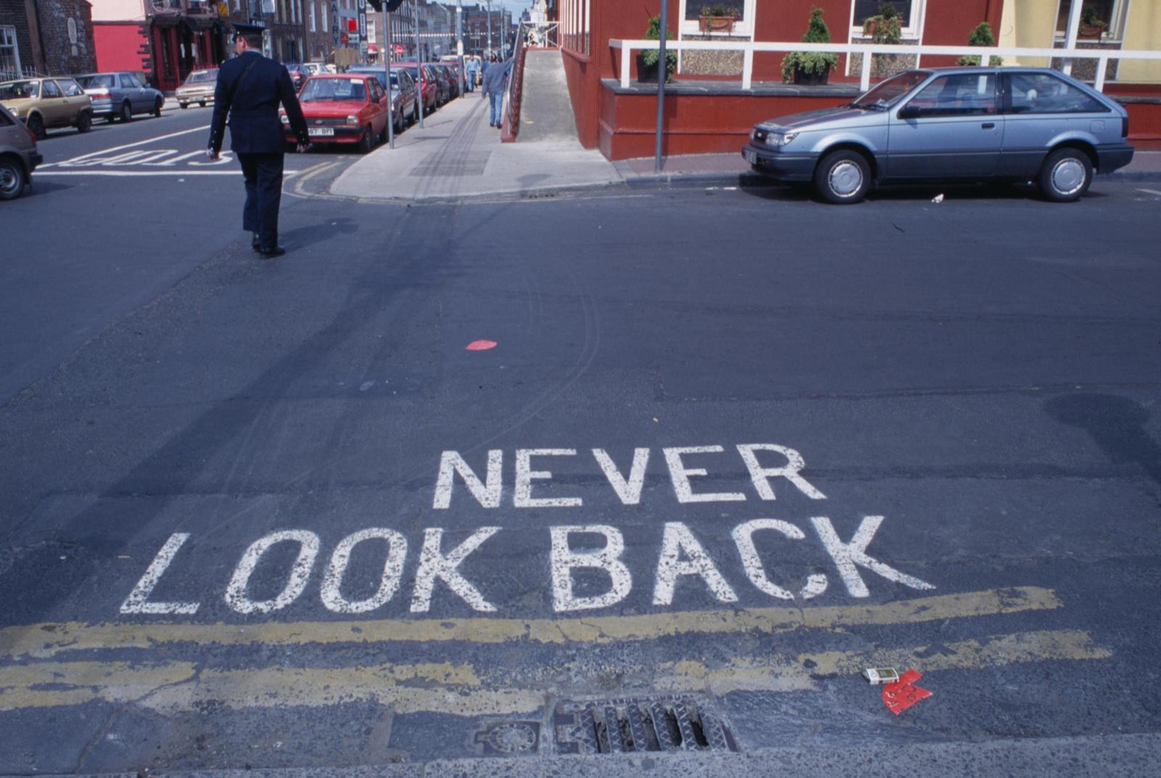 (1996) Jakob Gautel _ Jason Karaindros, Never Look Back, painted text on road.
