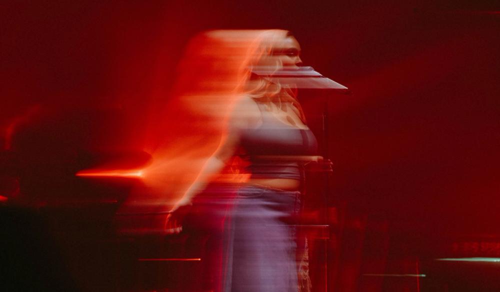 An artistically blurry photo of Jorja Smith with amber and orange tints