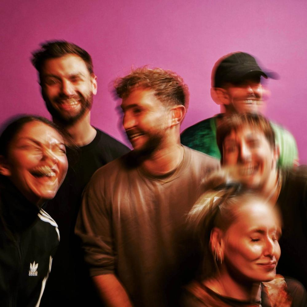 The members of UDC in front of a pink background