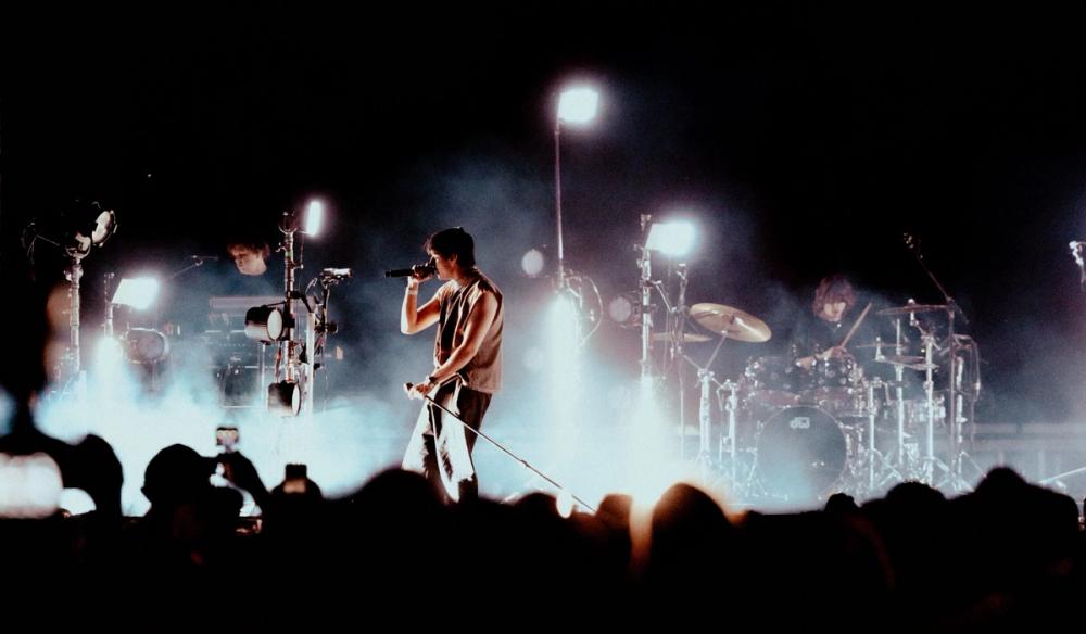 Artemas on stage with lighting towers around him