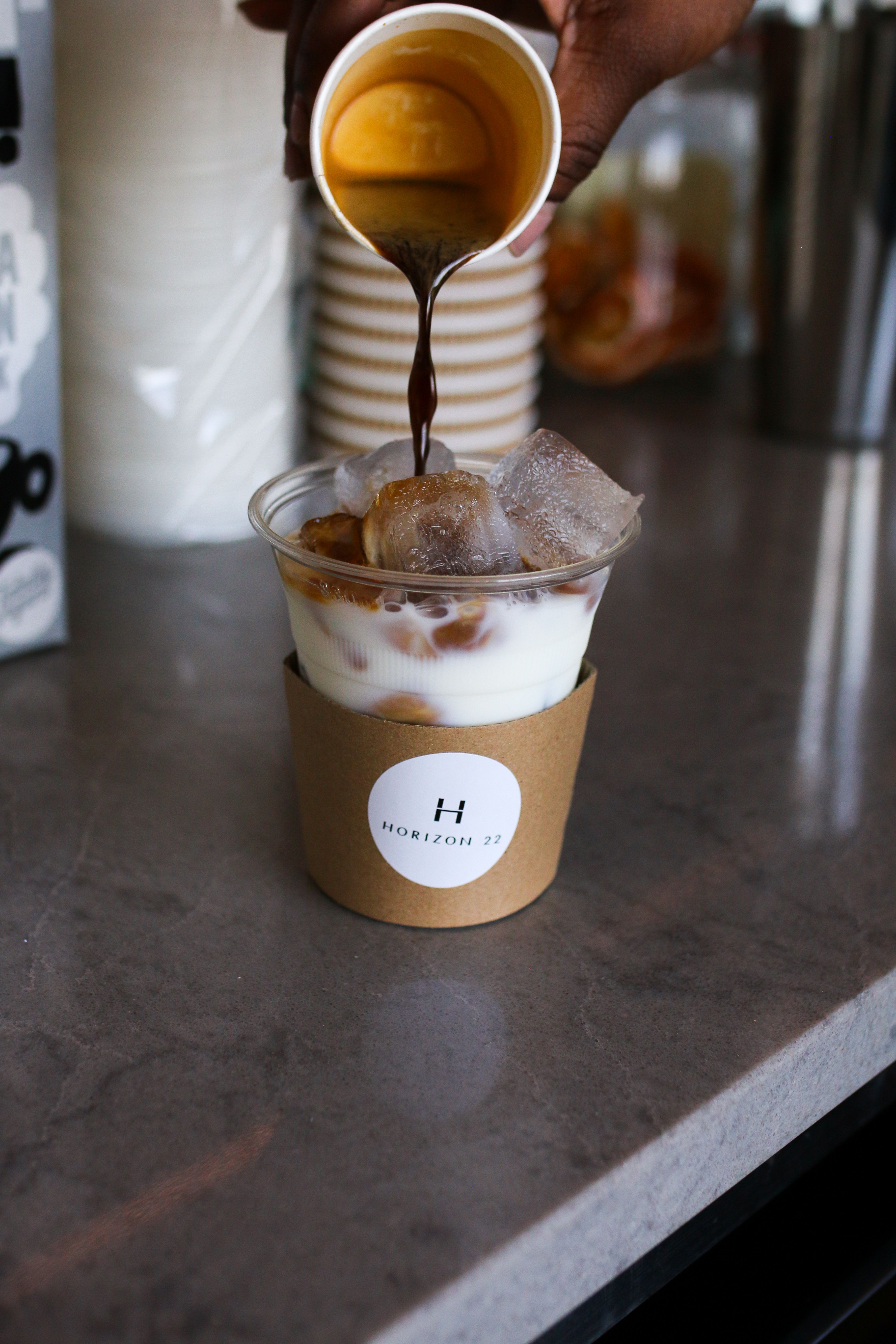 Pouring espresso into a takeaway iced coffee