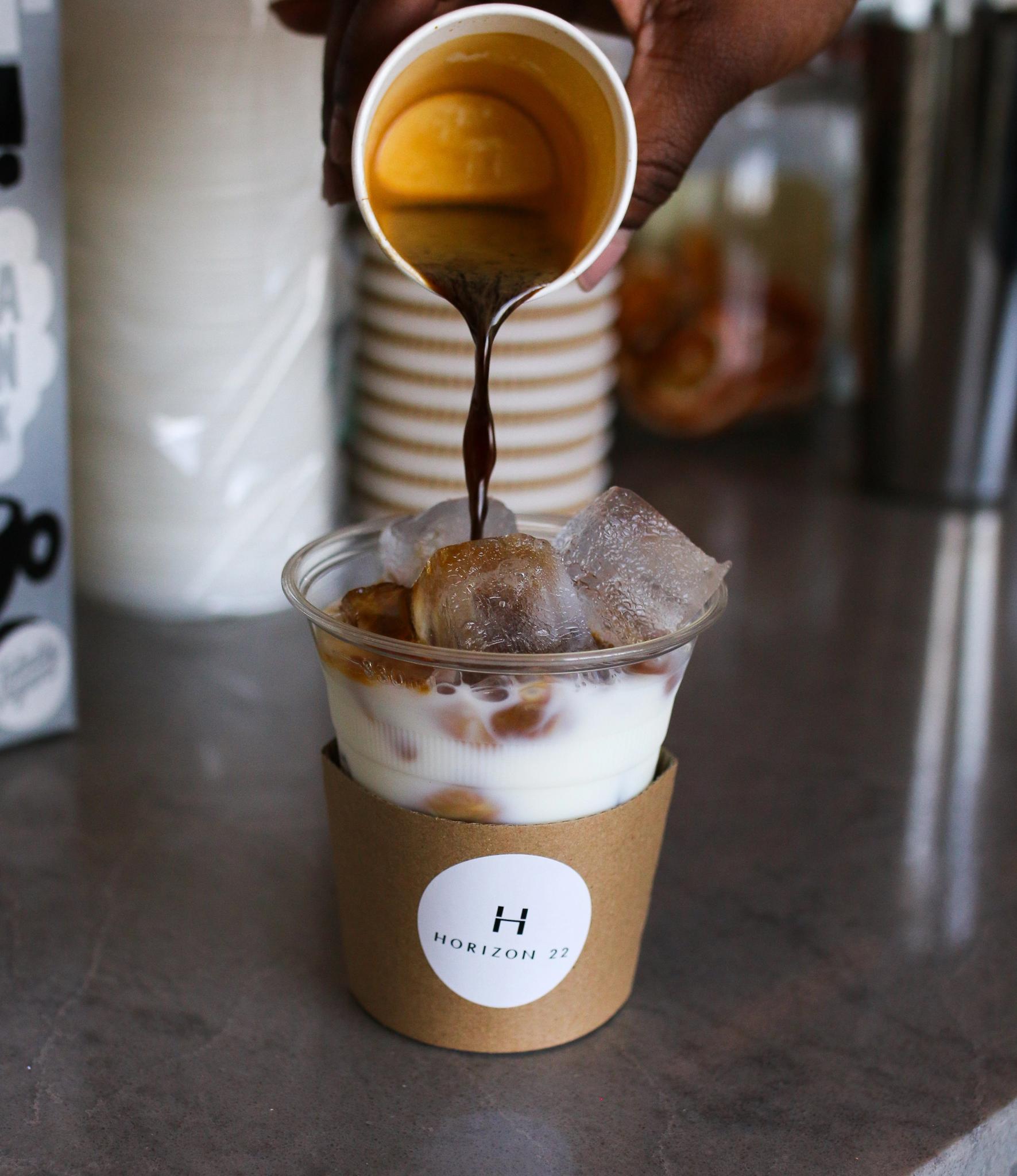 Pouring espresso into a takeaway iced coffee