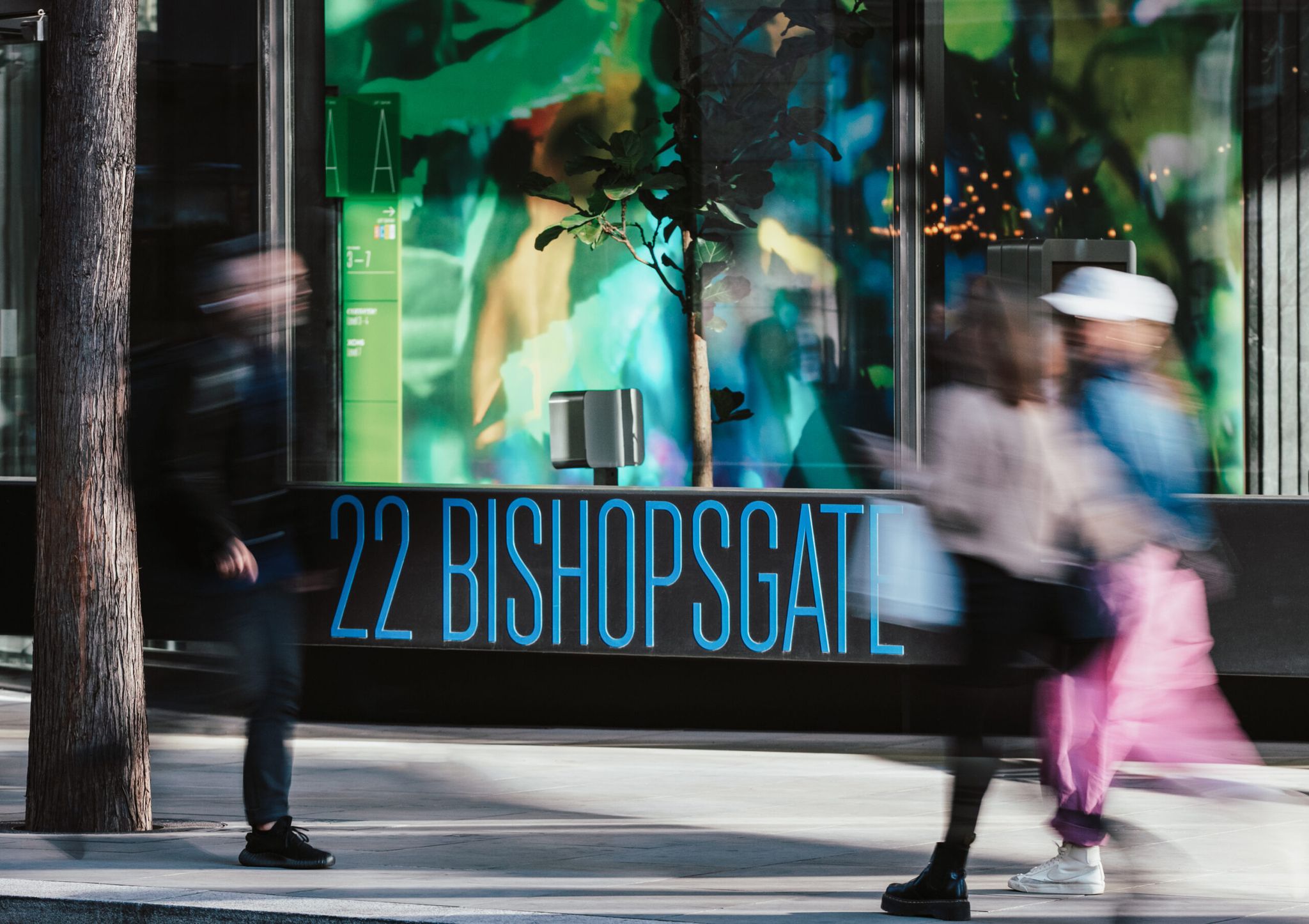 People walking past 22 Bishopsgate sign