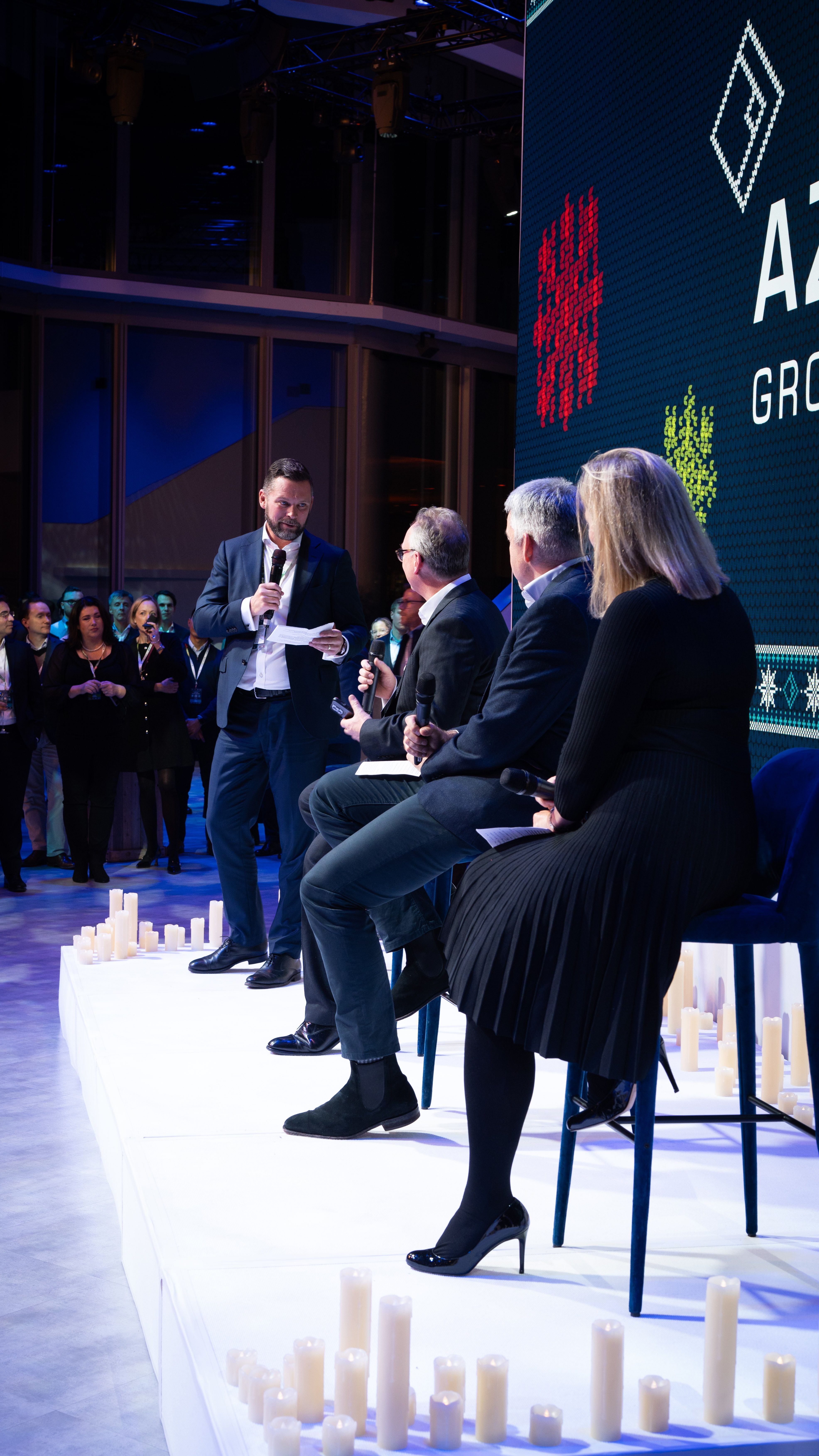 Man speaking on a microphone in front of crowd