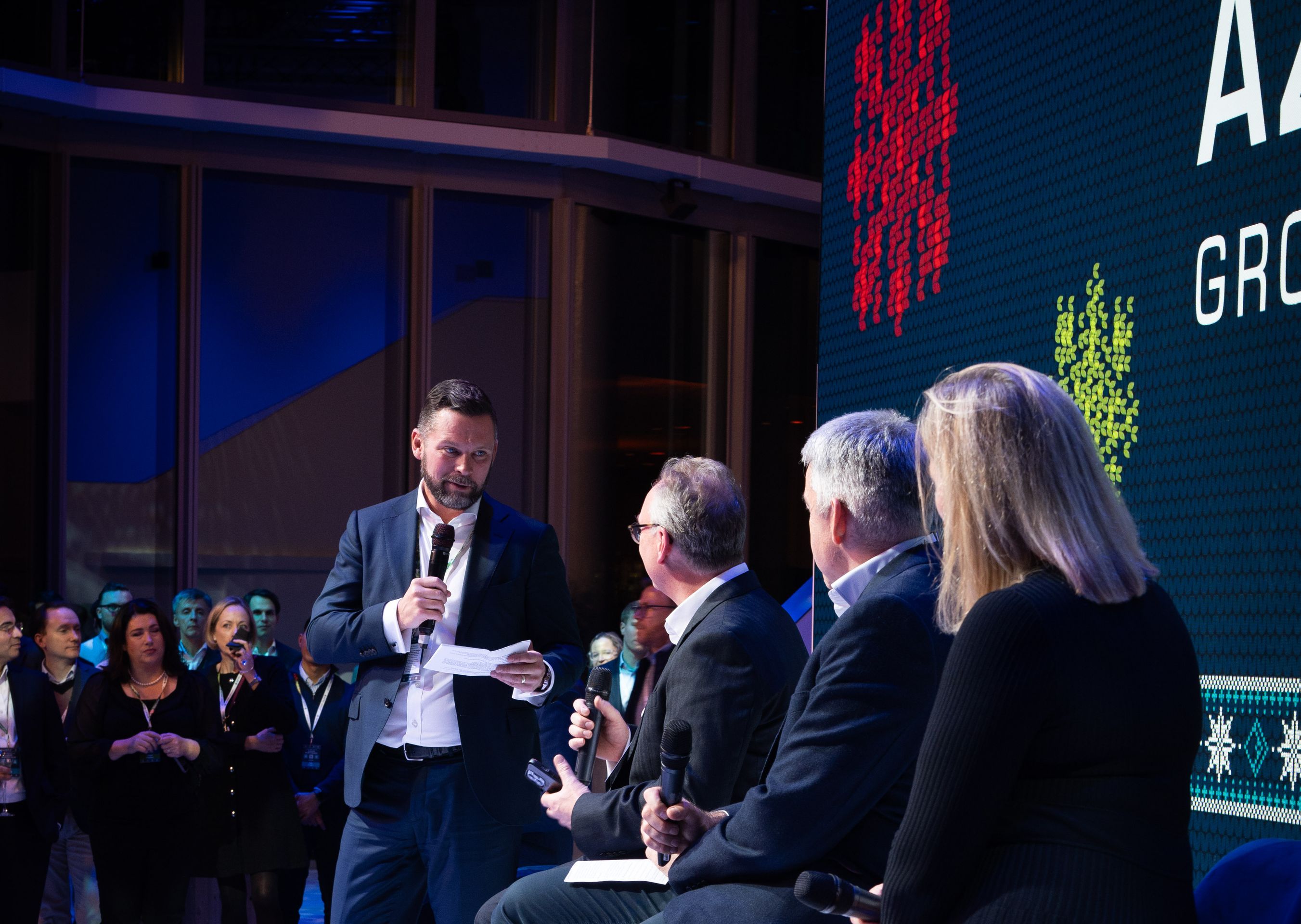 Man with microphone in front of panel