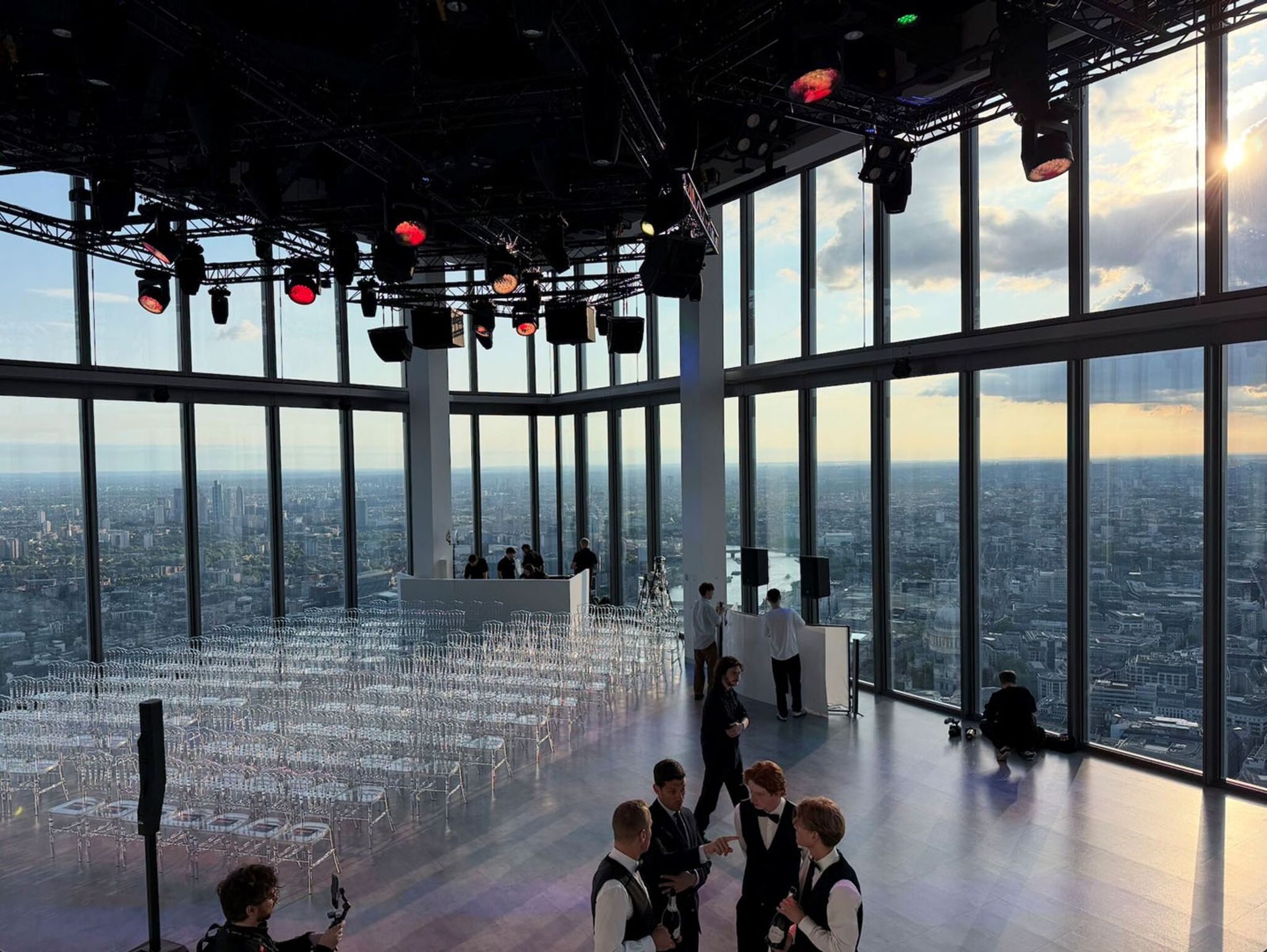 The Horizon 22 at sunset, with rows of clear plastic chairs ready for an event. Out of the window, the sprawling city of London is easily visable. 