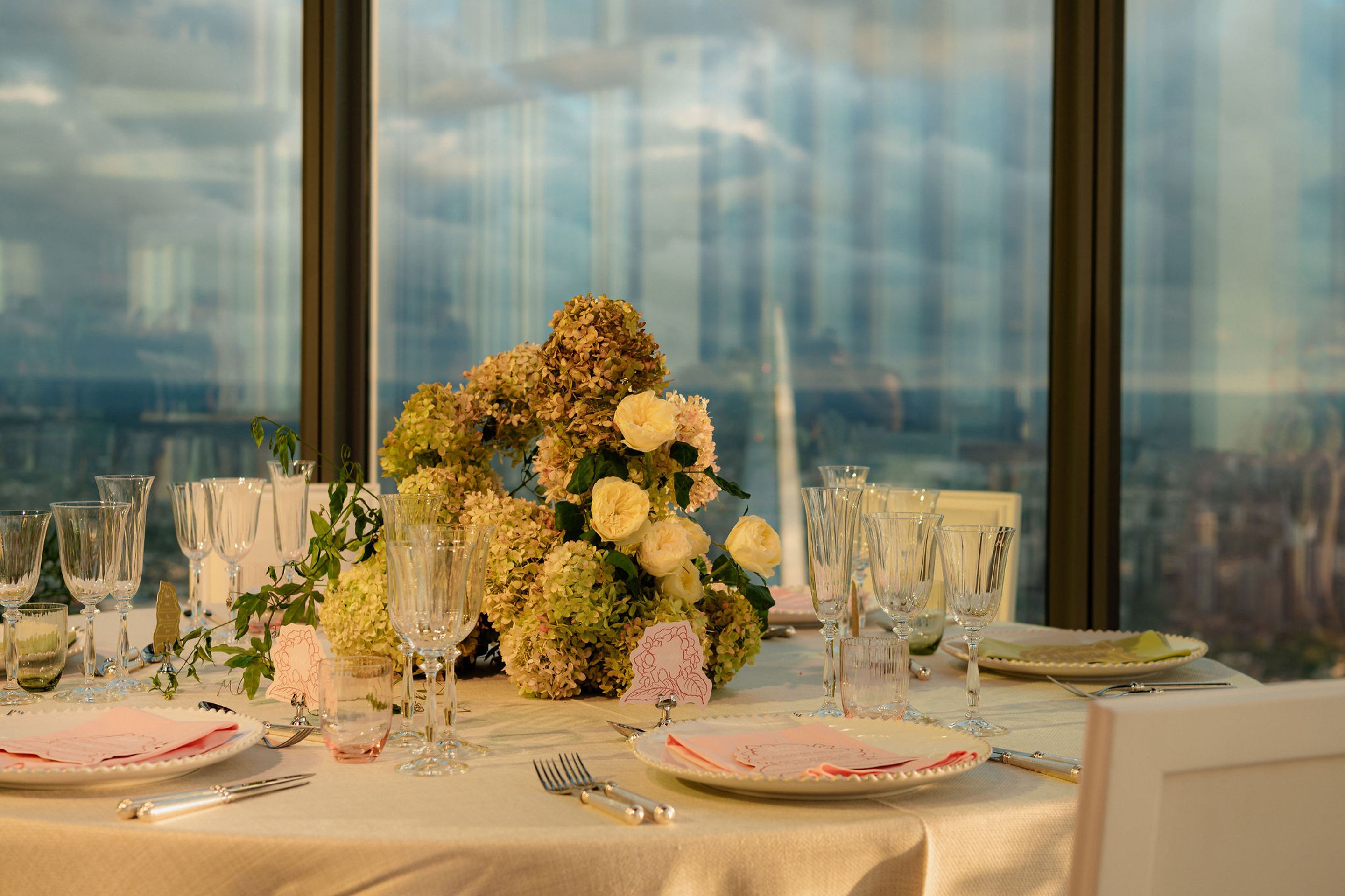 Elegant pavlova dessert topped with fresh strawberries, edible flowers, and microgreens, served on a white plate.