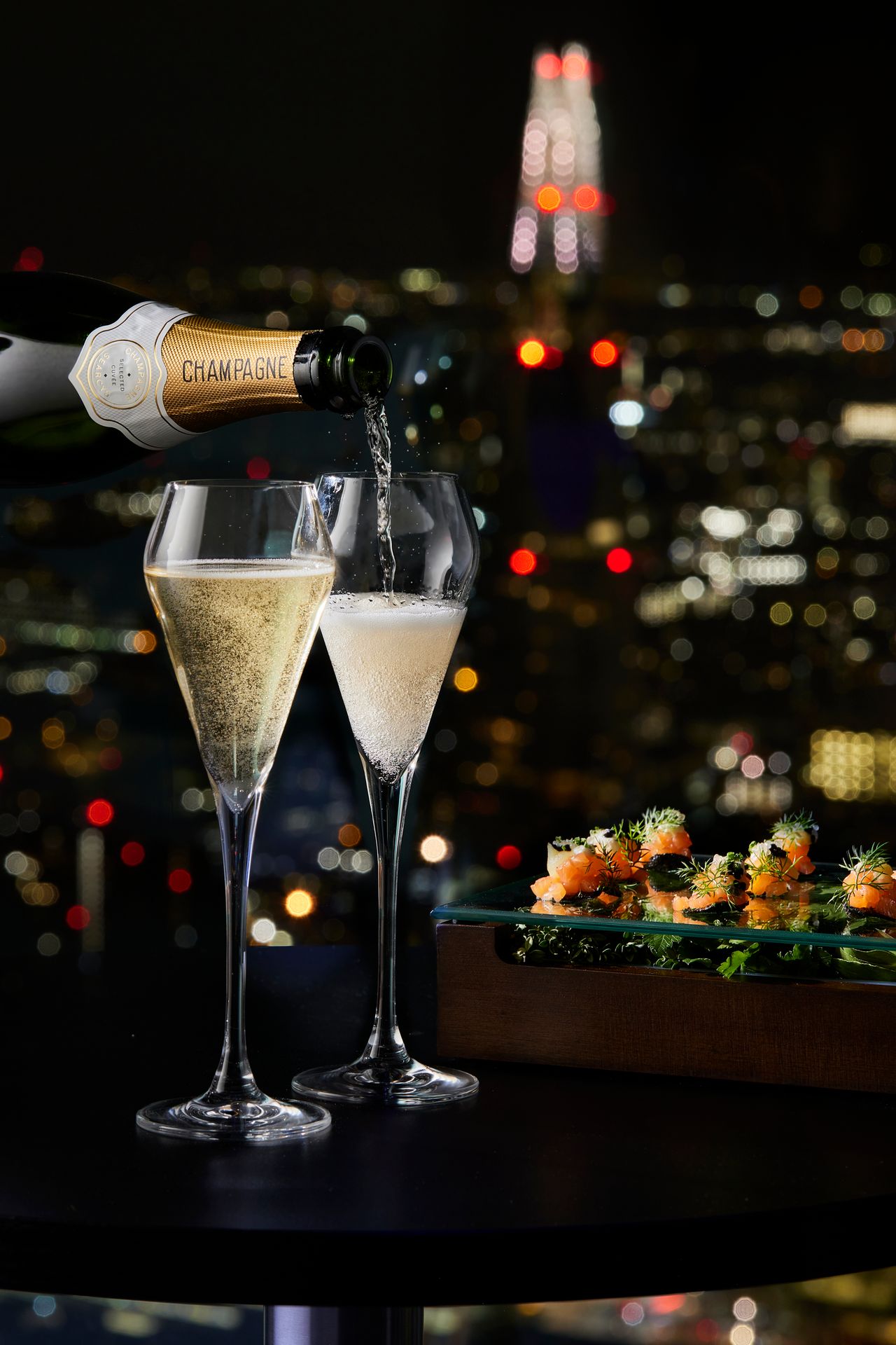 Champagne glasses with night skyline