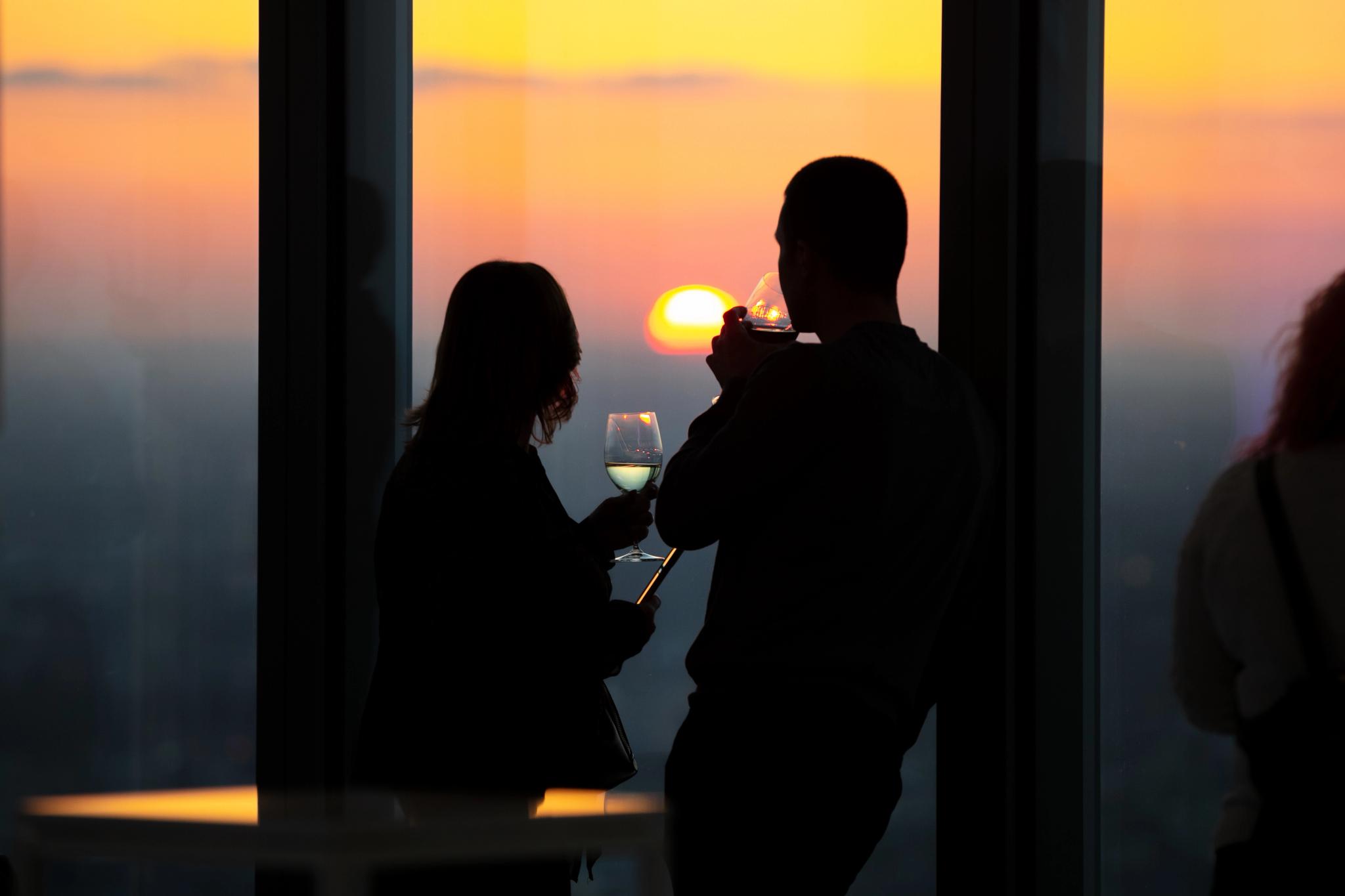 Two people silhouetted against a sunset 