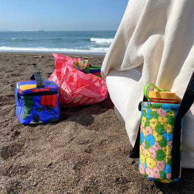 water bottle sling and other summer bags on the beach