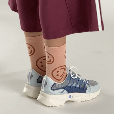 baggu happy sock on model in trainers and sweatpants