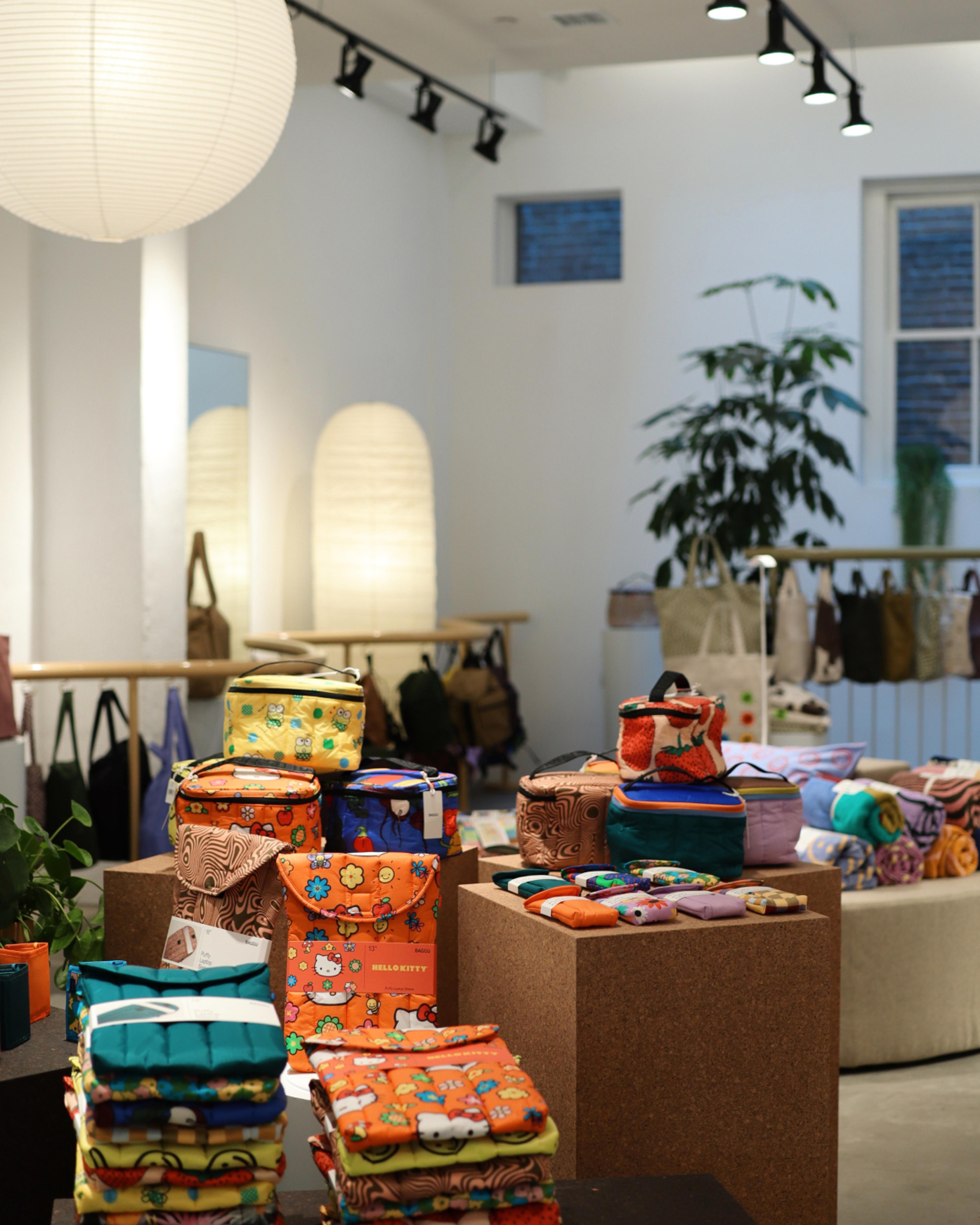 Laptop cases, bags, and towels are displayed on cork cubes inside Baggu SoHo in New York City.