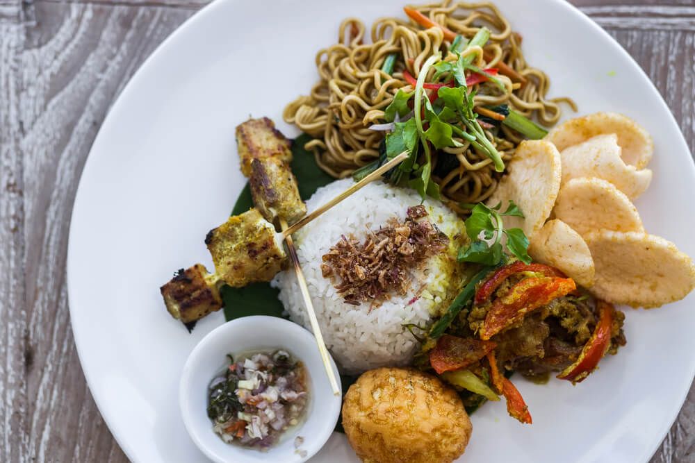 an-assortment-of-balinese-cuisine-displayed-on-a-plate,-featuring-vibrant-colors-and-diverse-flavors.