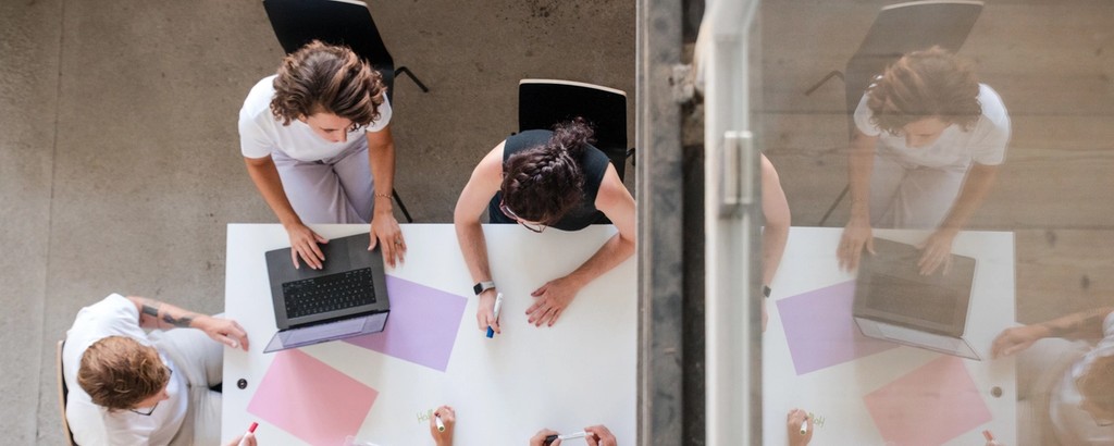 Awareness Agentur Team bei der Arbeit rund um einen Tisch