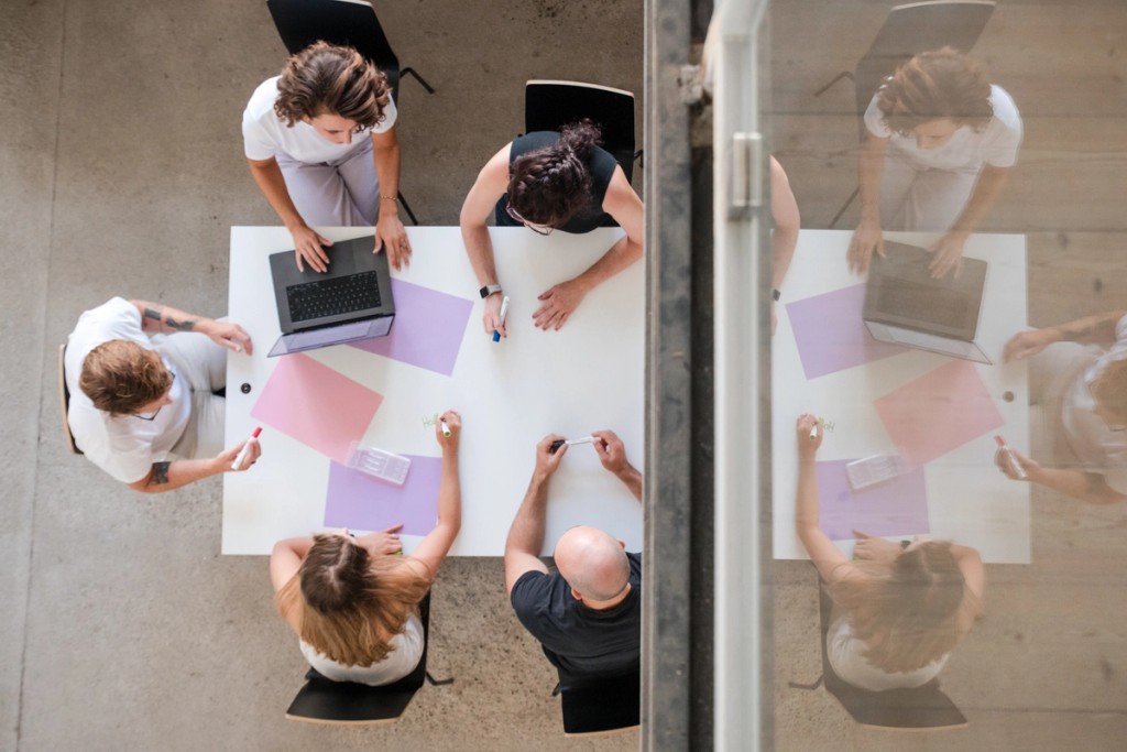 Awareness Agentur Team bei der Arbeit rund um einen Tisch