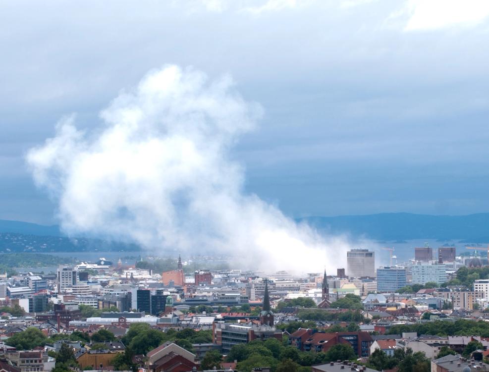 A large cloud of smoke from a building in a city