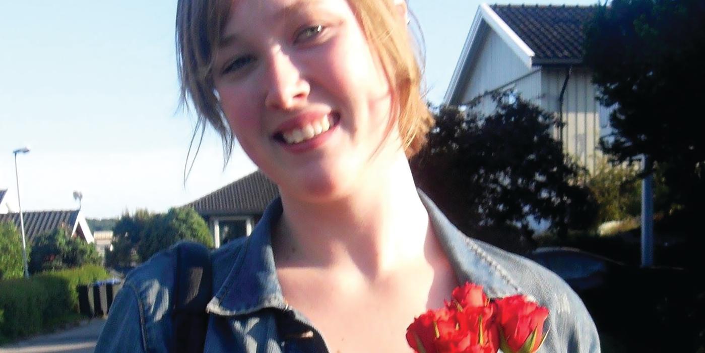 Portrett av en smilende ung med røde roser.