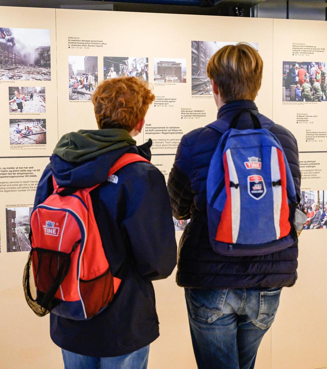 Two boys look at a timeline with pictures and text.