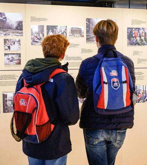 To gutter ser på en tidslinje med bilder og tekst.