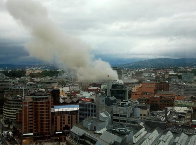 Et bybilde på en overskyet dag. Røyk fra en brann i en av bygningene stiger opp i luften.