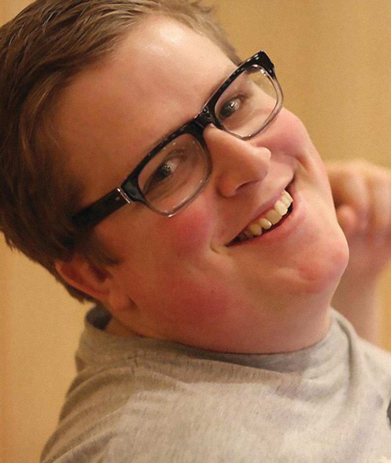 Portrett av en med briller mann som smiler. Beige bakgrunn. Foto