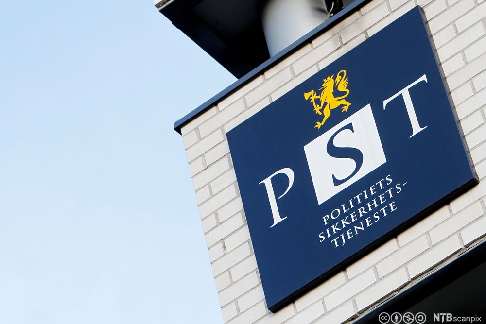 Bygning med et skilt. Mørke blå logo. Gul løve på toppen. Teksten: PST Politiets sikkerhetstjeneste