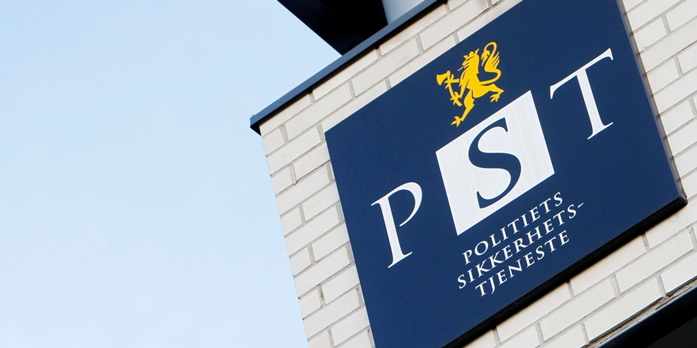 Building with a sign. Dark blue logo. Yellow lion on top. The text: PST Police security service