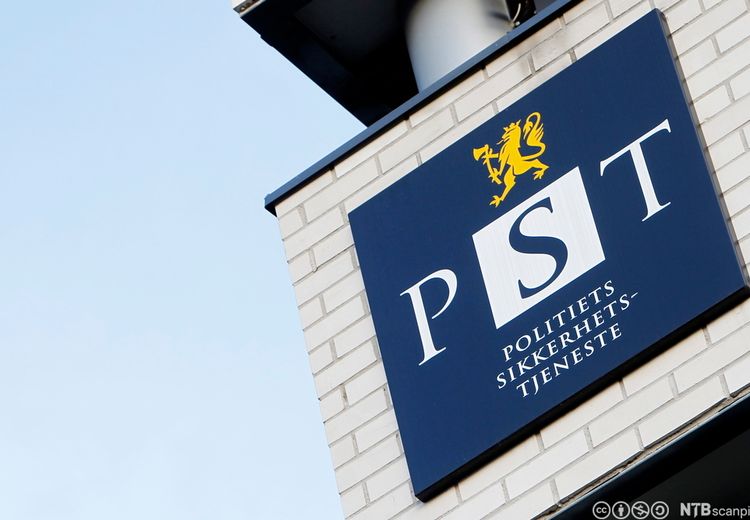 Building with a sign. Dark blue logo. Yellow lion on top. The text: PST Police security service