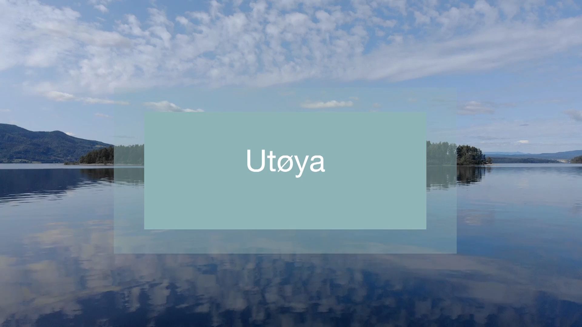 Foto av en øy, med en blå plakat over, der man leser "Utøya". 