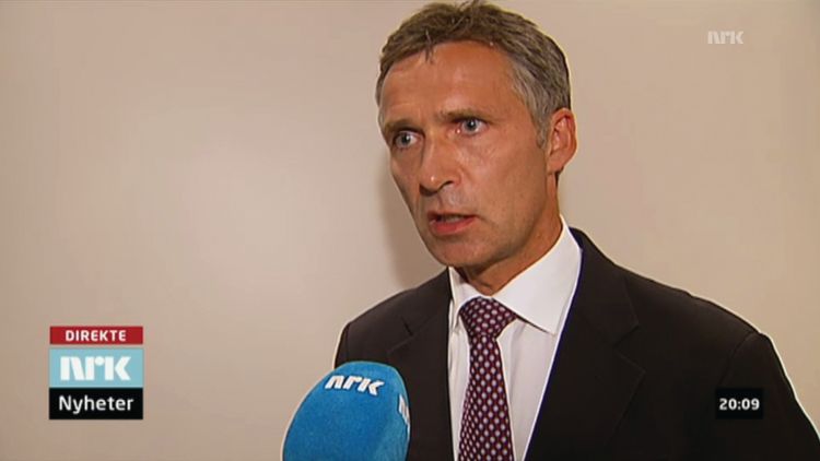  Screenshot from NRK. Man in a suit with white in the background. Blue microphone in front. Text: "direct NRK Nyheter."
