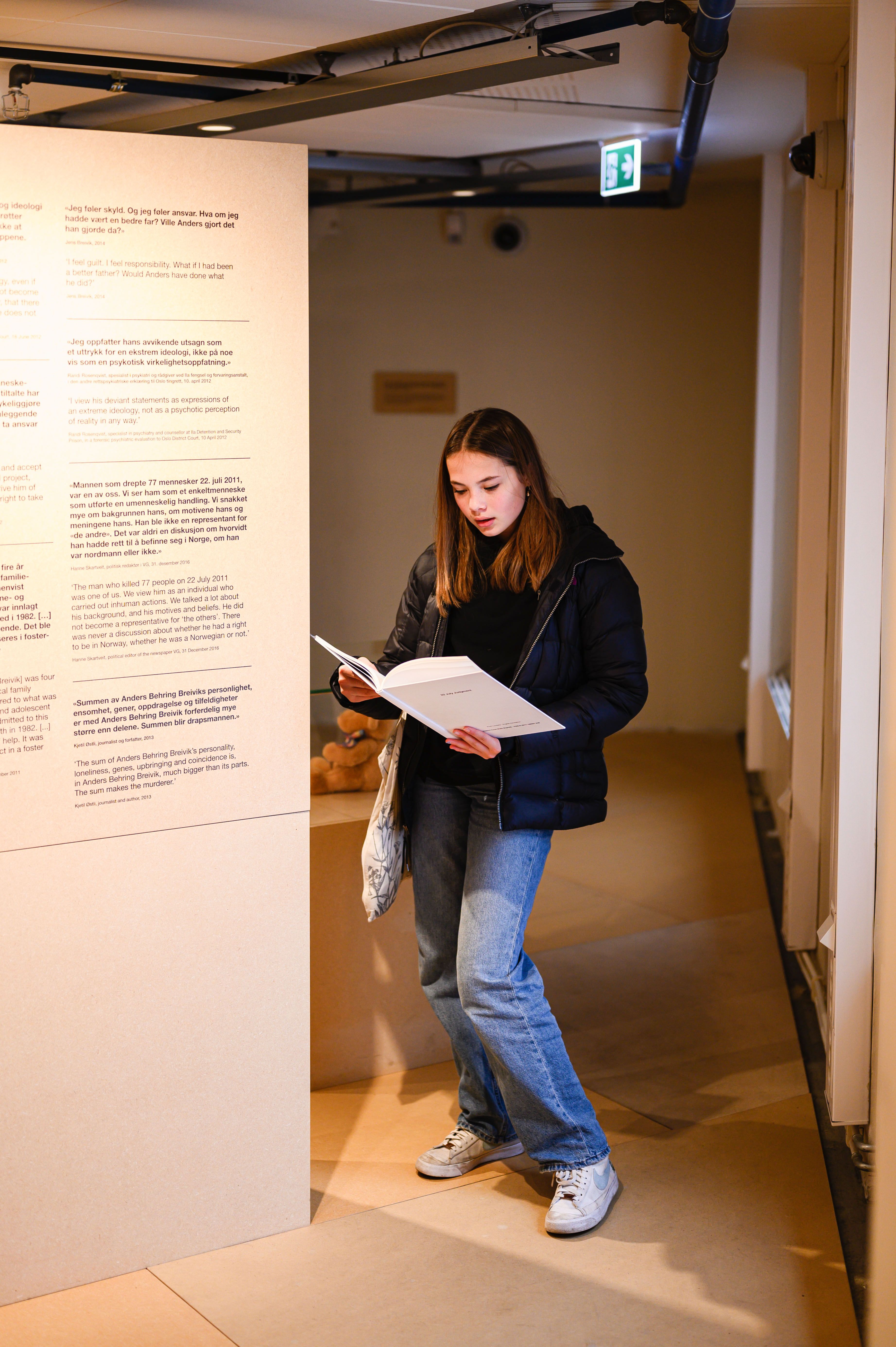 En person leser bok i utstillingen. Et utstillingselement.