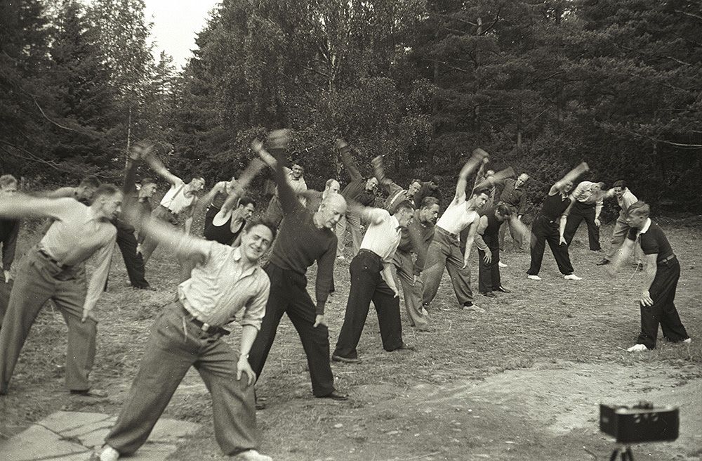 Black and white photo of a group of approx. 25 men training in a glade.