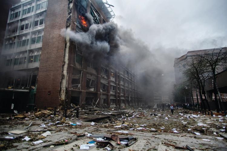 Fire in brick building. Big clouds of smoke. Debris of building material on the ground. Photo.